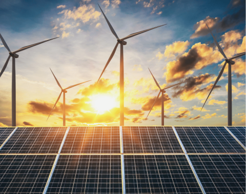Zonnepanelen en windmolens bij zonsondergang